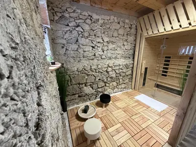 a bathroom with a stone wall and wooden floor at Apartma Devs in Kranjska Gora