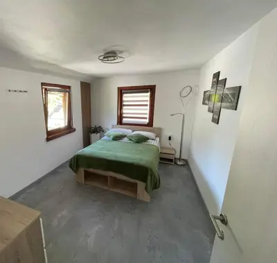 a bedroom with a green bed and a window at Apartma Devs in Kranjska Gora