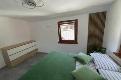 a bedroom with a green bed and a window at Apartma Devs in Kranjska Gora