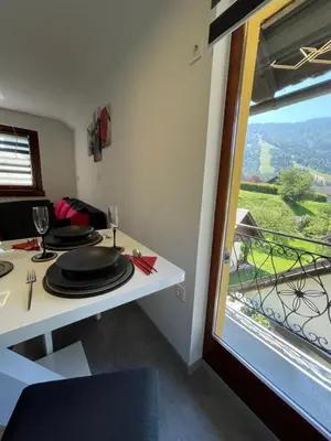 a dining room with a table and a window at Apartma Devs in Kranjska Gora