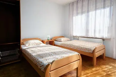 a bedroom with two beds and a window at Apartma Maka in Maribor