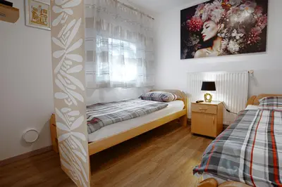 a small bedroom with a bed and a window at Apartma Maka in Maribor