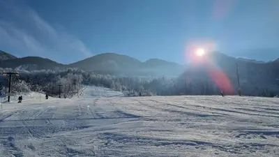 a snow covered ski slope with the sun in the background at Nad tunelom apartment Bohinj in Bohinj