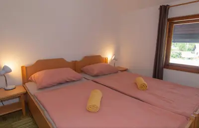 a bedroom with a bed with two slippers on it at Nad tunelom apartment Bohinj in Bohinj