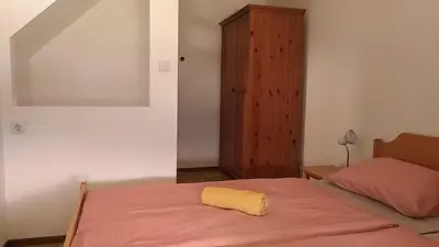a bedroom with a bed with a yellow towel on it at Nad tunelom apartment Bohinj in Bohinj