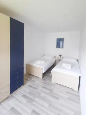 a bedroom with two beds and a blue cabinet at Harmony House Velenje in Velenje