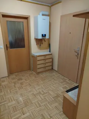 a room with a door and a dresser and a kitchen at Apartma Kaj in Kaja in Maribor