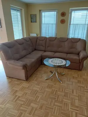 a brown couch in a living room with a table at Apartma Kaj in Kaja in Maribor