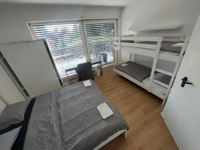 a bedroom with bunk beds and a desk and a window at ROSE VALLEY, modern studios & apartments in Ljubljana