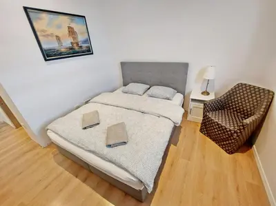 a small bedroom with a bed and a chair at ROSE VALLEY, modern studios & apartments in Ljubljana