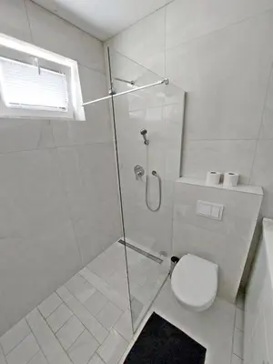 a bathroom with a glass shower with a toilet at ROSE VALLEY, modern studios & apartments in Ljubljana