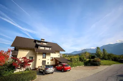a house with two cars parked in a driveway at Apartment Planika in Bohinj