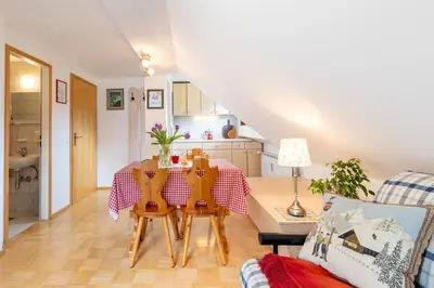 a living room with a table and chairs at Apartment Planika in Bohinj