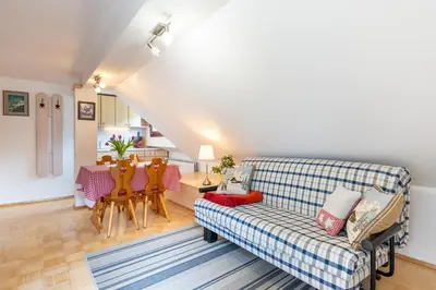 a living room with a couch and a table at Apartment Planika in Bohinj