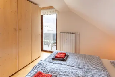 a bedroom with a bed and a large window at Apartment Planika in Bohinj