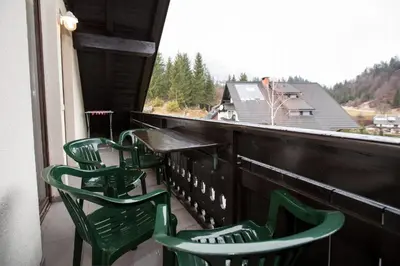 a group of green chairs on a balcony with a view at Apartment Planika in Bohinj