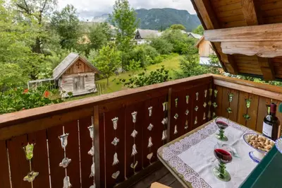 a table with glasses of wine on a balcony at Apartments Omahen in Bohinj