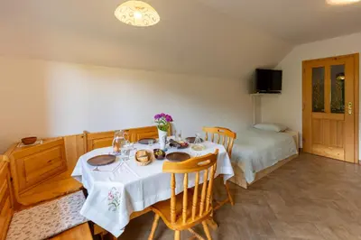 a dining room with a table and a bed at Apartments Omahen in Bohinj