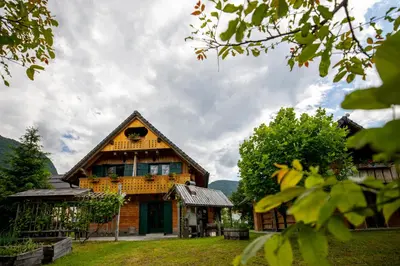 a large wooden house with a gambrel at Apartments Omahen in Bohinj