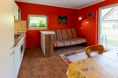 a kitchen with red walls and a couch in a room at Apartments Darinka Mencinger in Bohinj
