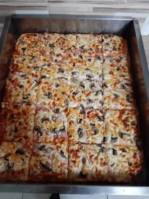 a large pizza with cheese and olives in a pan at Turistično - Izletniška kmetija Žerjav in Brežice