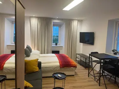 a bedroom with a bed and a table and a television at Celje Luxury Apartment in Celje