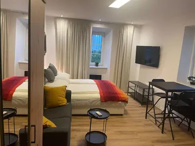 a bedroom with a bed and a table and a television at Celje Luxury Apartment in Celje