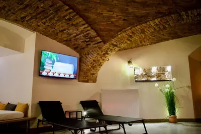 a living room with two chairs and a flat screen tv at Celje Luxury Apartment in Celje