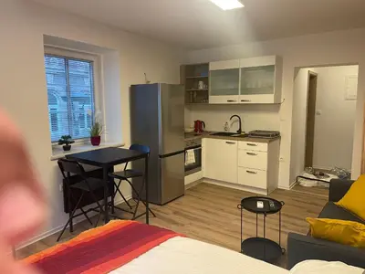 a kitchen and living room with a table and a refrigerator at Celje Luxury Apartment in Celje