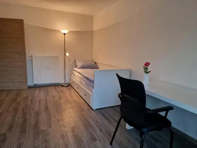 a bedroom with a bed and a desk and a chair at Orange house Šempeter in Šempeter v Savinjski Dolini