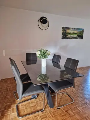 a dining room table with chairs and a vase of flowers at Orange house Šempeter in Šempeter v Savinjski Dolini