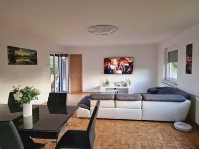 a living room with a white couch and a table at Orange house Šempeter in Šempeter v Savinjski Dolini