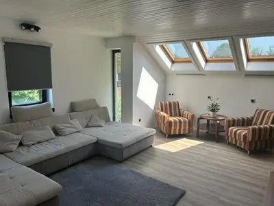 a living room with a couch and a table and windows at A&E Apartment in Ljubljana