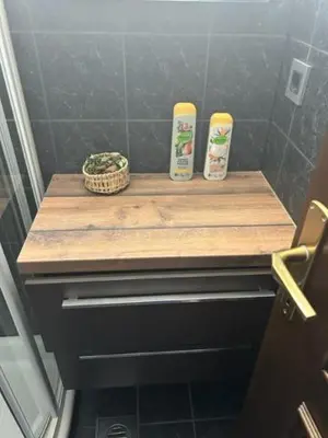 a bathroom with a wooden counter with two bottles of shampoo at A&E Apartment in Ljubljana