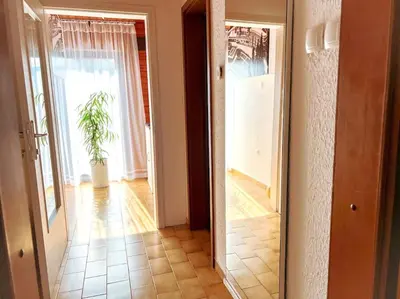 a hallway with a door leading to a room with a plant at Apartma Kenda in Bled