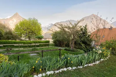 a garden with flowers and mountains in the background at Apartment Lilija in Bovec