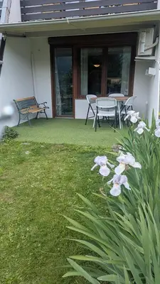 a patio with a table and chairs and flowers at Apartment Lilija in Bovec