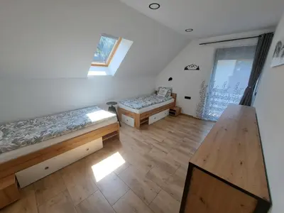 an attic room with two beds and a window at Riverside Apartma 2, Kranjska Gora in Kranjska Gora
