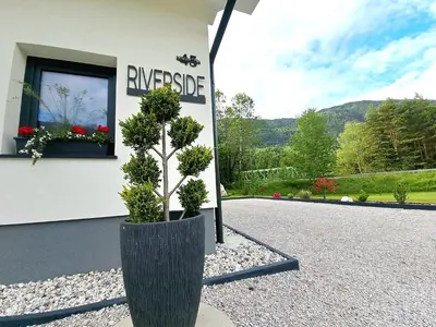 a plant in a pot in front of a building at Riverside Apartma 2, Kranjska Gora in Kranjska Gora