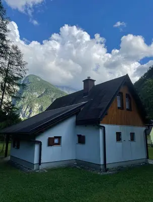 a white house with a wooden roof at Juliana Cottage in Soča