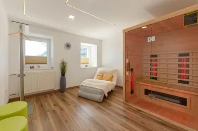 a living room with a glass shower and a chair at Holiday House Žalec in Griže