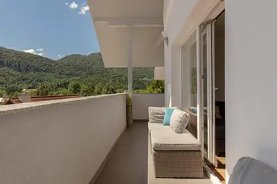 a balcony with a couch and a view of mountains at Holiday House Žalec in Griže