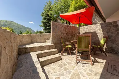 a patio with a table and a red umbrella at Holiday House Žalec in Griže