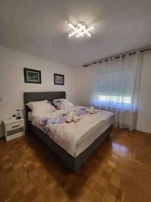 a bedroom with a bed and a window at Apartmaji Peric in Ljubljana