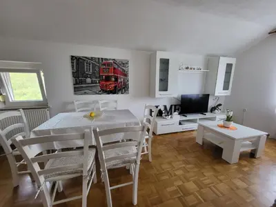 a dining room with a table and a red bus on the wall at Apartmaji Peric in Ljubljana