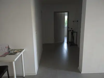 an empty room with a hallway with a table and a door at Počitniška hiša Hum in Kojsko