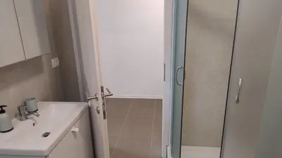a bathroom with a sink and a glass shower door at Počitniška hiša Hum in Kojsko