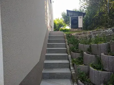 a set of stairs next to a wall with a tv at Počitniška hiša Hum in Kojsko