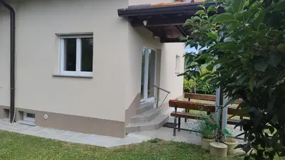 a house with stairs and a window and a tree at Počitniška hiša Hum in Kojsko