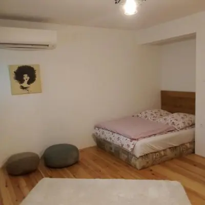 a bedroom with a bed and two ottomans at Apartmaji BORŠTNER in Vransko